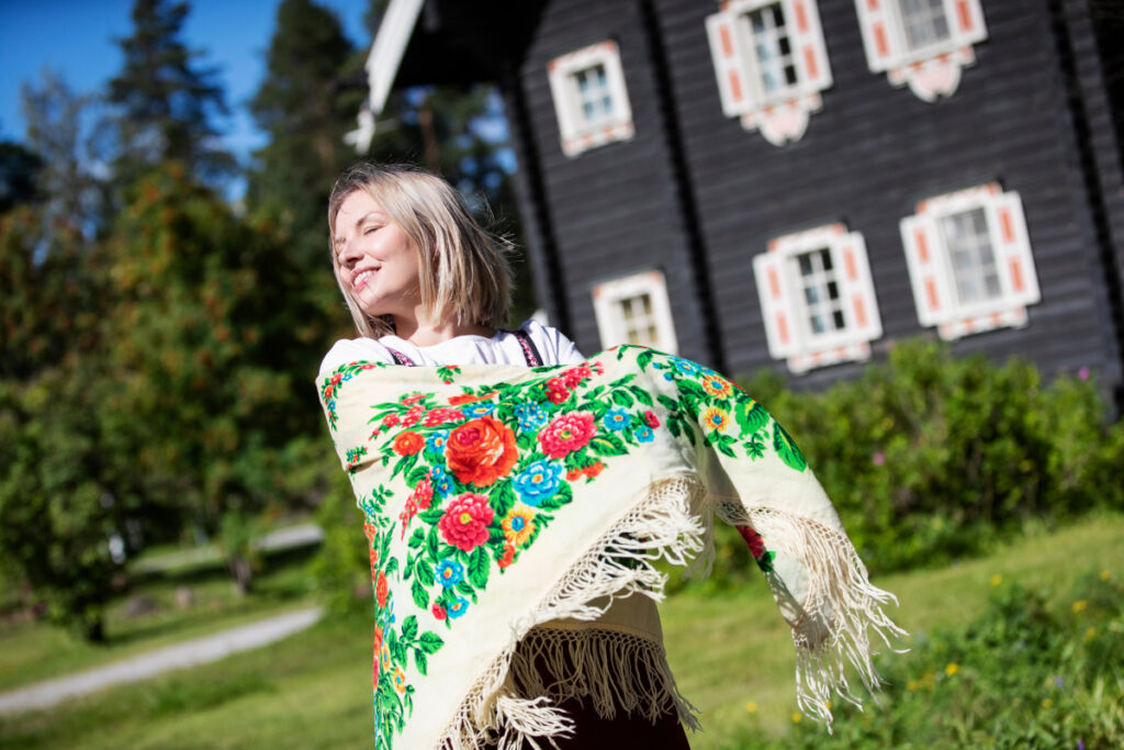 Samimatkat-myyttinen-suomi-kiertomatkat: kuvassa Tyttö Bomban talon vierellä